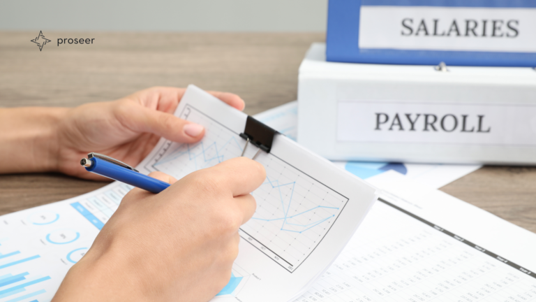 Hands reviewing payroll charts and documents with a blue pen and the Proseer logo.